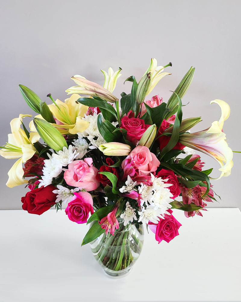 really large flower arrangement with lilies and roses in a vase