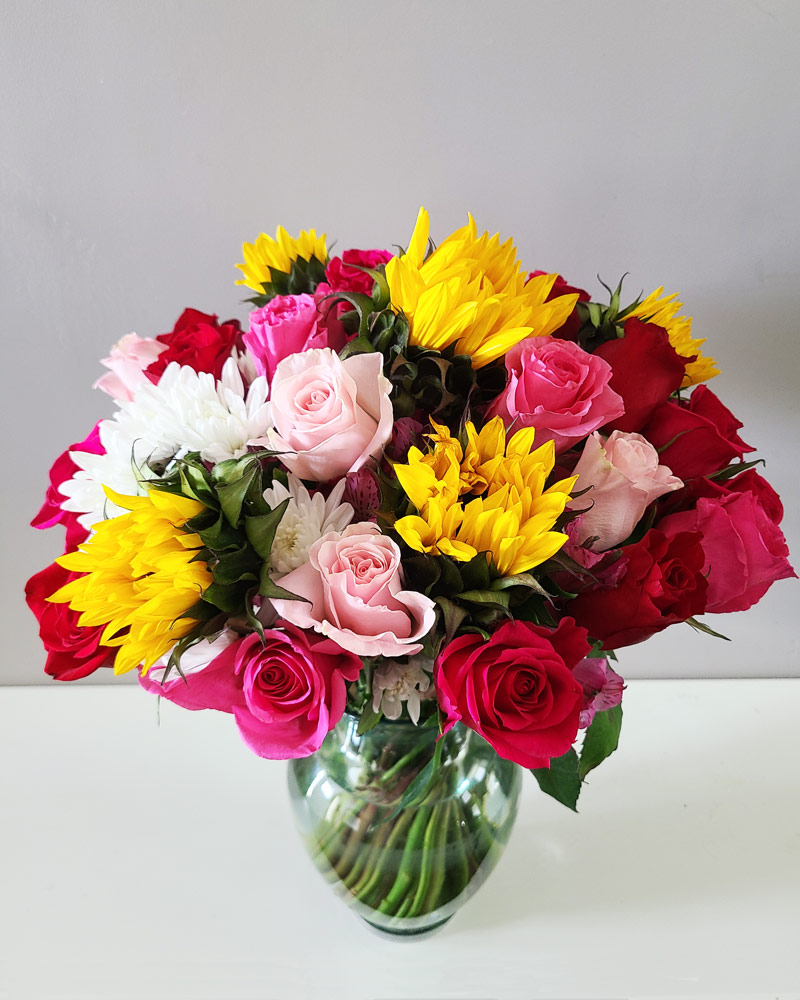 really large flower arrangement with sunflowers and roses in a vase